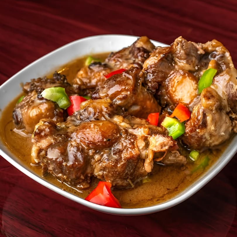 Supreme Seafood & Suya's African oxtail stew, garnished with red and green bell peppers.